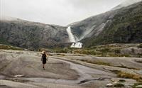 Person joggar mot fossane i Husedalen.