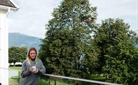 Gjest som slappar av på uteserveringa med utsikt mot Hardanger-naturen.