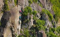 Gruppe klatrar via ferrata-ruta ved Valhall i Odda, med hengebruke og jernstiftar festa i berget.