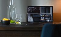 Arbeidsområde med bærbar PC og forfriskningar på Hardanger House, ideelt for produktivitet.