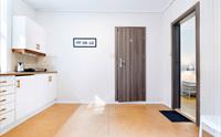 Moderne kjøkken med lyse overflater, praktiske fasilitetar og enkel tilgang til hotellrommet.