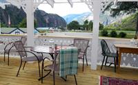 En terrasse med bord og stoler for bespisning.