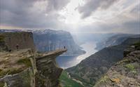 Trolltunga badar i dramatisk lys over Hardangerfjorden, ein ikonisk destinasjon for eventyrlystne turgåarar.