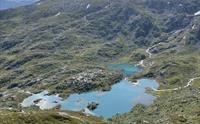 Utsikt over grønne fjellsider og et vann.