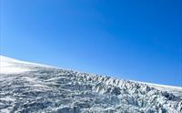 Kvinne sitter og ser utover Buerbreen, en del av Folgefonna.