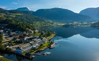 Luftfoto av Brakanes Hotel i Hardanger, med utsikt over fjord, fjell og vakre omgjevnader.