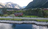 Et dronebilde av Ingrids Apartments, med fjellene i bakgrunnen.