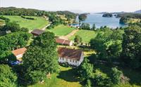 Dronebilete av Halsnøy Kloster med fjorden i bakgrunnen.