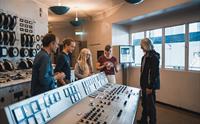 Gruppe besøkande inne i kontrollrommet på Kraftmuseet, der dei lærer om norsk energihistorie.