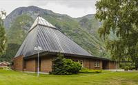Eidfjord nye kirke sett fra utsiden. Den er laget av rød murstein med en trekantet glasstak.