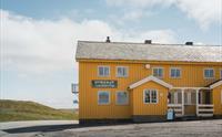 Den gule Dyranut Turisthytta, med blå himmel i bakgrunnen.