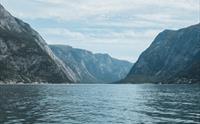 Storslagen natur langs Osafjorden i Hardanger, med rolege fjordvatn og bratte fjellsider.