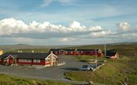 Dyranut Fjellstova med blå himmel i bakgrunnen.