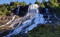 Furubergsfossen i full straum – Eit imponerande bilete av Furubergsfossen som sender store mengder vatn nedover fjellsida.