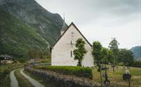 Viser kirken og gravplassen bak inngangen.