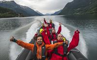 Smilande turistar nyt fartsfylt RIB-safari på Hardangerfjorden.