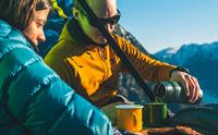 Eit par nyt kaffi og kjeks i solskinet medan dei heng på ein portaledge i fjellveggen over Hardangerfjorden. Uforgløymeleg oppleving i naturen.