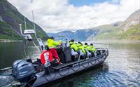 En ribbåt fylt med passasjerer som forlater kaien.