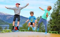 Born hoppar og kosar seg på trampolinen med fjordutsikt i Mikkelparken
