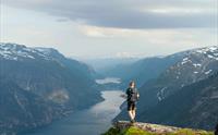 Person står og ser utover naturen, deriblant Folgefonna isbre.
