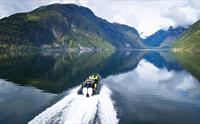 Full fart på fjorden! RIB-båten susar gjennom Hardangerfjorden med spektakulær utsikt rundt.