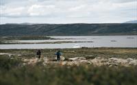 Et landskapsbilde som viser «Halnekongen»-båten ved land på avstand.