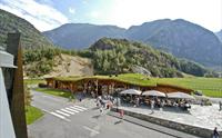 Hardangerviddahallen, en trebygning med gress og geiter på taket, sett fra utsiden.