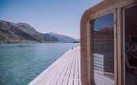 Heit Grimo sauna sett fra siden på bryggen med klar fjordutsikt.