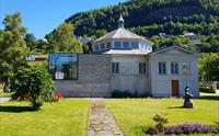 Uteområde ved Ingebrigt Vik Museum, med historisk arkitektur og grøne hagar.