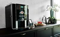 En automatisk kaffemaskin og en orkide som sitter på siden.
