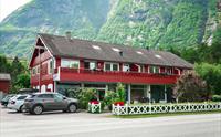 Ingrids Apartments sett fra utsiden, med biler parkert foran.
