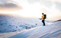 Einmannstur på truger over snødekte åsar i Hardanger.