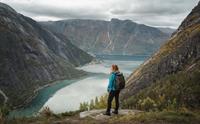 En kvinne i blå jakke står ved utsiktspunktet Kjeåsen og ser ned på fjorden.