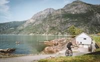 En oversikt over Kråkeskarvet strandområde med mye folk, en syklist og garderobebygget.