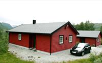 To av de enkelte hyttene med bil parkert foran.