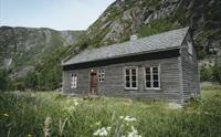 Det største av de gamle husene på Måbødalen museum, lunt i det grønne gresset.