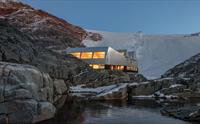 Moderne arkitektur ved Fonna1199 med isbreen Folgefonna i bakgrunnen, midt i Hardanger sitt majestetiske landskap.