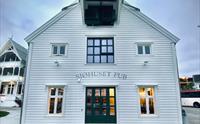 Sjøhuset Restaurant & Pub i Norheimsund - en koselig restaurant ved vannkanten med store vinduer som vender ut mot Hardangerfjorden. Moderne nordisk interiørdesign med naturlige treelementer og stemningsfull belysning.