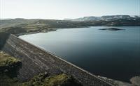 Et dronebilde av Sysendammen-demningen under solnedgang.