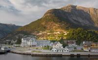 Et dronebilde av Eidfjord havn og turistinformasjonen.
