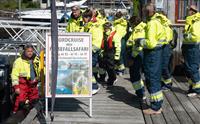 Turistar i klare gule drakter gjer seg klare til fjordcruise og fossefall-safari i Hardanger.
