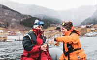 Folk kosar seg med eit glas sider på RIB tur