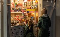 To barn står foran salgsbod med sukkertøy utstilt
