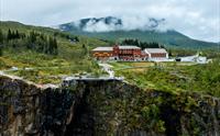 Et dronebilde av Fossli Hotel som ligger rett ovenfor fossen.