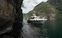 Pilagutt i ein spektakulær fjordkorridor, omkransa av bratte fjellsider og urørt natur – ei eventyrleg fjordreise.