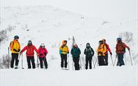 En gruppe fargerike skigåere på topptur i Hardanger.