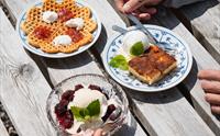 Tradisjonelle norske dessertar på Olaløo – vaflar med syltetøy, brennsnut og vaniljeis med friske bær.