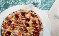 Heimelaga vedfyrt pizza servert på Olaløo – ein smaksoppleving i Hardanger.