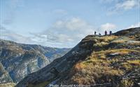 Fjellvandrarar på rygg med vid utsikt over fjellandskap i Hardanger, perfekt for fotturar og naturopplevingar