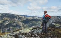Vandrar med ryggsekk ser utover storslått fjellandskap i Hardanger, populært område for fjellturar